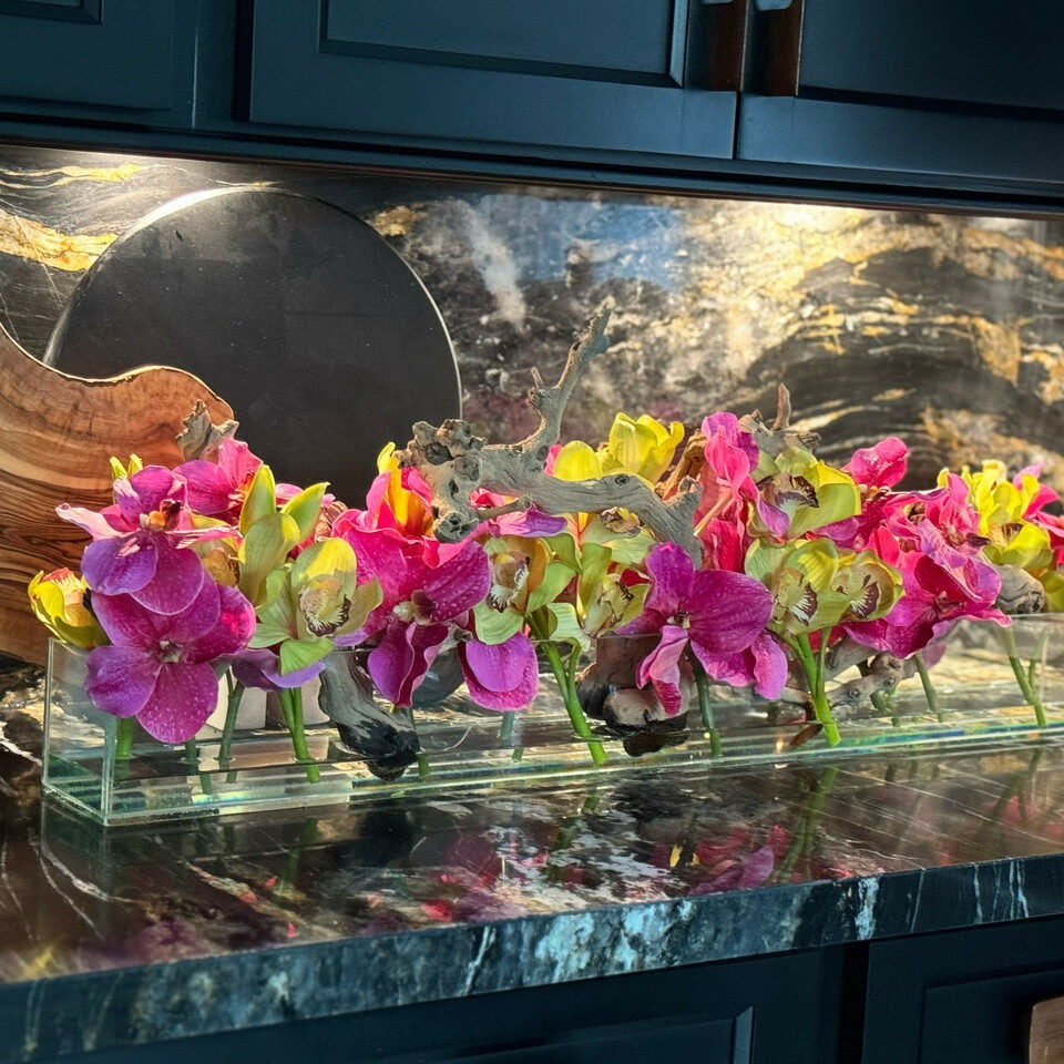 Moderne Hausvase aus Glas mit rosa Vanda-Orchidee und grünen Cymbidien
