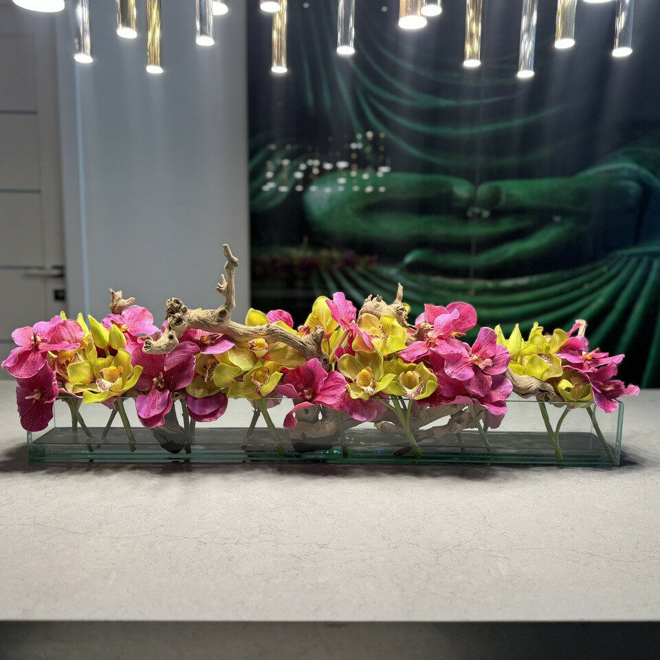 Moderne Hausvase aus Glas mit rosa Vanda-Orchidee und grünen Cymbidien
