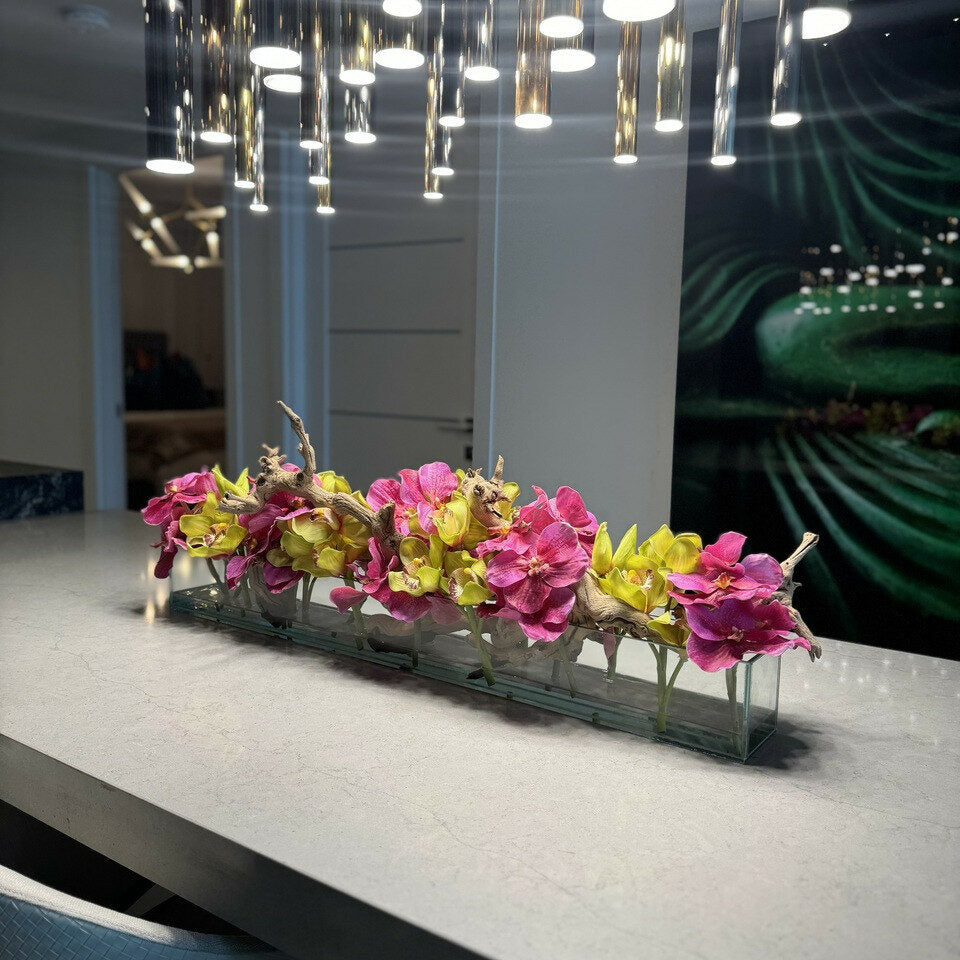 Moderne Hausvase aus Glas mit rosa Vanda-Orchidee und grünen Cymbidien